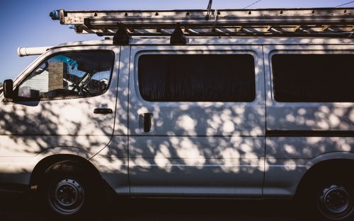 White work van with a ladder on the roof